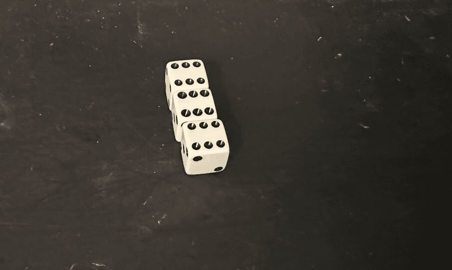 tres dados alineados sobre fondo negro
